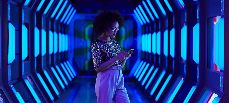 A woman stands in a hallway illuminated by blue lights, creating a serene and modern atmosphere.