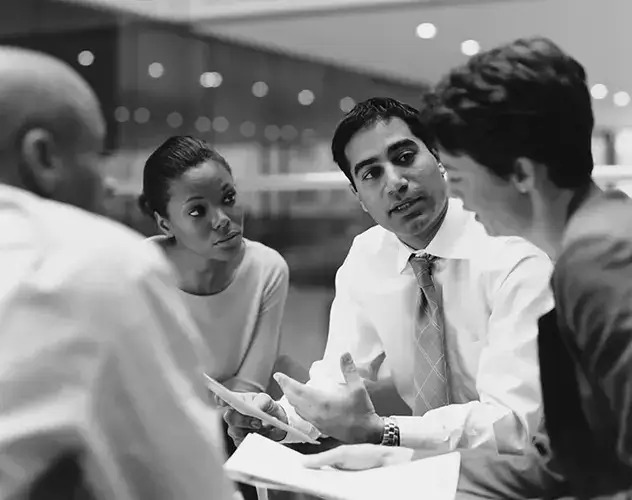 A diverse group of professionals discussing business strategies at a conference table.